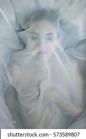 A Woman Under White Fabrics In Water