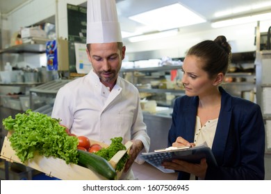 woman undergoing inspection in restaurant kitchen - Powered by Shutterstock