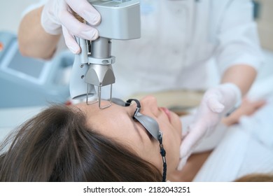 Woman undergoing a procedure for removing neoplasms with a laser - Shutterstock ID 2182043251