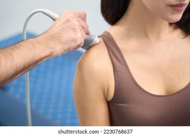 Woman is undergoing shoulder examination on clinic with ultrasound machine - Shutterstock ID 2230768637