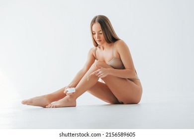 Woman in underwear with slim body type is posing in the studio.