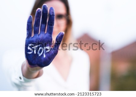 Woman with unfocused face and hands painted by feminism