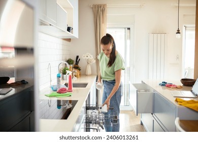 Woman unloading clean dishes from dishwasher at home - Powered by Shutterstock