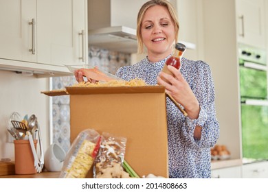 Woman Unpacking Online Meal Food Recipe Kit Delivered To Home