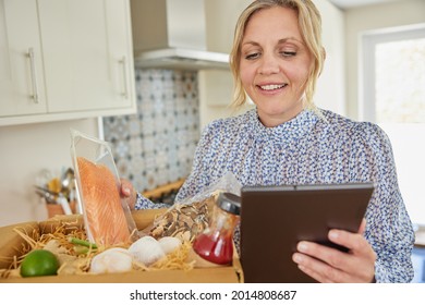 Woman Unpacking Online Meal Food Recipe Kit Delivered To Home