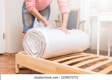 Woman Unrolling New Mattress 