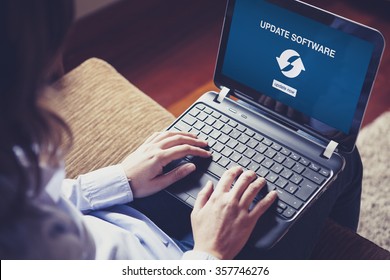 Woman Updating Laptop Computer Software Sitting At Home. Updating Software Notification In The Screen.