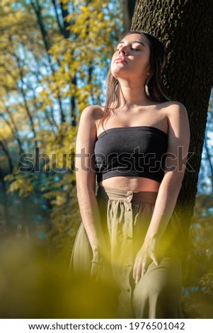 Similar – Beautiful young photographer woman wearing black clothes, sitting on the floor in countryside with her camera