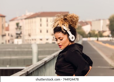 Woman urban portrait wearing headphones and sporty clothes