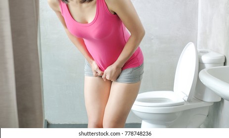 woman with urine urgency in the toilet
