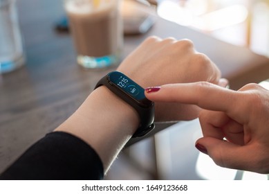 Woman Use Apps On Smart Bracelet. Tocuh Display With Right Hand