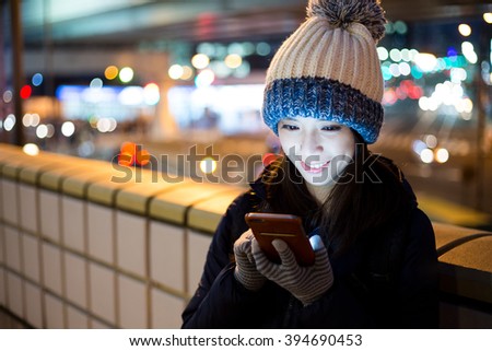Woman use of cellphone in Tokyo city at night