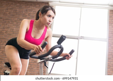 Woman Use Exercise Bike And Training Hard