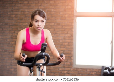 Woman Use Exercise Bike And Training Hard