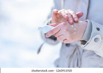 Woman Use Hand Cream On Dry Hand. Skin Care Concept. Close Up Of A Woman Hand Hydrating Skin Applying Cream In Winter. 