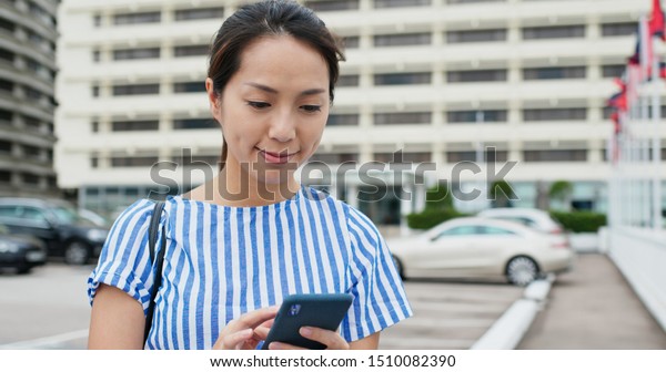 Woman use of mobile phone with the background car\
park lot