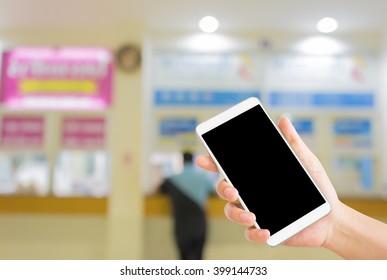 Woman Use Mobile Phone And Blurred Image Of A Man At Bus Station Counter