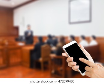 Woman Use Mobile Phone And Blurred Image Of People In Court Room