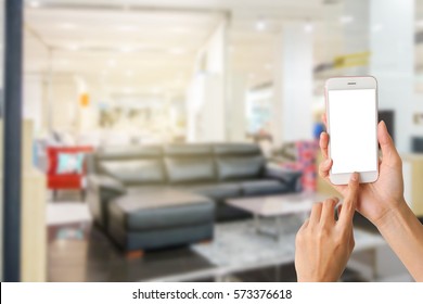 Woman Use Mobile Phone And Blurred Image Of Furniture Shop In Shopping Mall