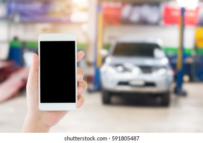 Woman Use Mobile Phone And Blurred Image Of The Automobile Repair Shop