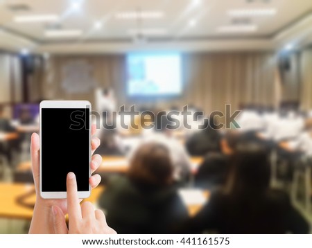 woman use mobile phone and blurred image of people are studying in classroom,people meeting in conference room