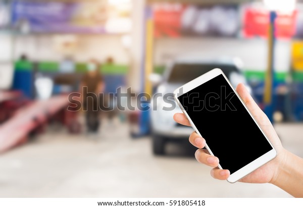 woman use mobile phone and blurred image of the
automobile repair shop