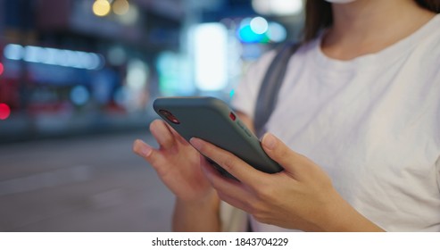 Woman use of mobile phone in city at night - Shutterstock ID 1843704229