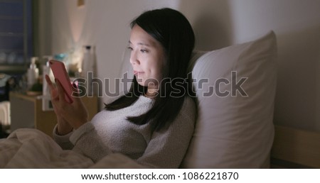 Woman use of mobile phone at home at night 