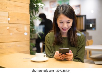 Woman Use Of Mobile Phone Inside Coffee Shop