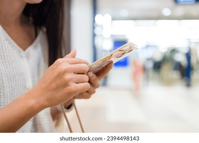Woman use of mobile phone at shopping mall - Shutterstock ID 2394498143