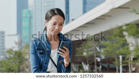 Woman use of mobile phone and sit on the bench