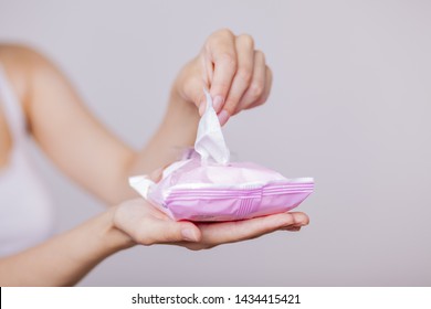 Woman use package of wet wipes and take one wipe