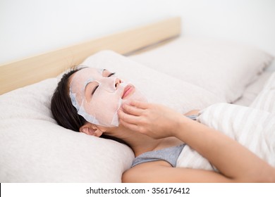 Woman use of the paper mask ans lay on the bed - Powered by Shutterstock