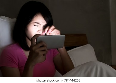 Woman Use Phone With Eye Problem On The Bed At Night