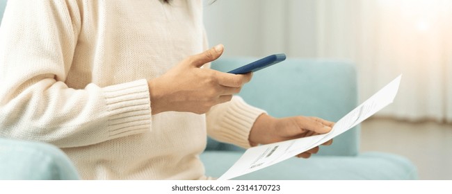 woman use phone scan barcode or QR codes to pay credit card bill after receiving document invoice. payment, receive, paying electricity, digital payments, technology, scanning, financial transactions