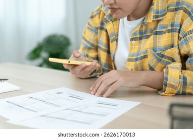 woman use phone scan barcode or QR codes to pay credit card bill after receiving document invoice. payment, receive, paying electricity, digital payments, technology, scanning, financial transactions