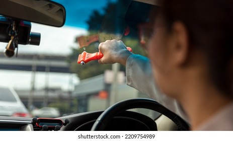 Woman Use Safety Hammer And Seatbelt Cutter In Cars, Break Glass When Emergency. In Case Of Emergency On Car Safety Red Hammers To Break The Grass Window.