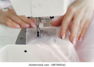 Woman use sewing machine. Designes sew cloth. Blonde in studio.