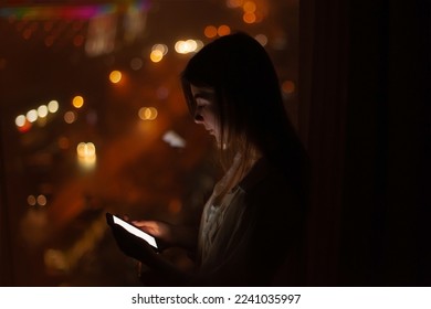 woman use smartphone at night. calls taxi through the application, orders home delivery of food. mobile phone searching for network - Shutterstock ID 2241035997