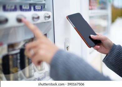 Woman use of soft drink vending system paying by cellphone - Shutterstock ID 390167506