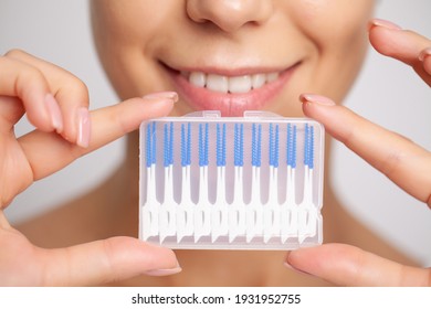 The woman uses brushes to clean the interdental spaces - Powered by Shutterstock