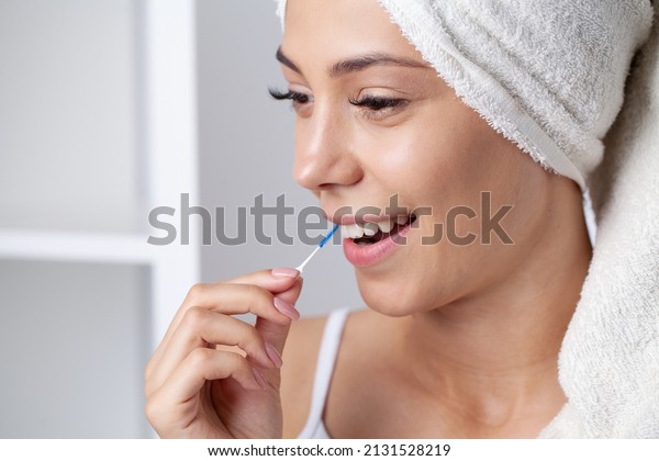 The\
woman uses brushes to clean the interdental\
spaces.