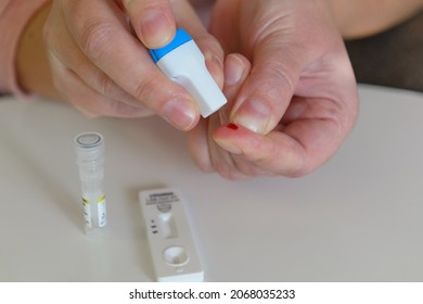 The Woman Uses A Lancing Device To Take A Blood Sample From Her Finger And Test For COVID19 Or Diabetes 