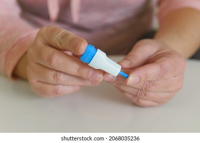 The Woman Uses A Lancing Device To Take A Blood Sample From Her Finger And Test For COVID19 Or Diabetes 