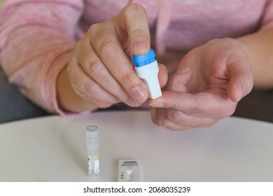 The woman uses a lancing device to take a blood sample from her finger and test for COVID19 or diabetes 