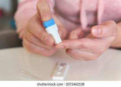 The Woman Uses A Lancing Device To Take A Blood Sample From Her Finger And Test For COVID19 Or Diabetes 