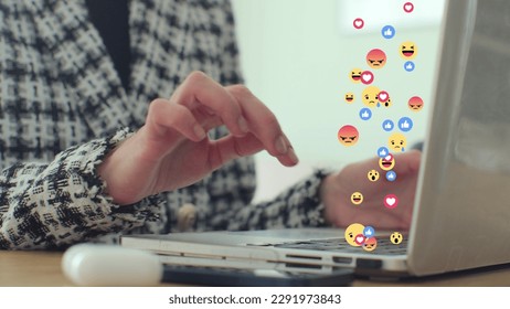 Woman uses laptop computer, types chat messages. 3D emoji, meme icons flying out of device. - Powered by Shutterstock