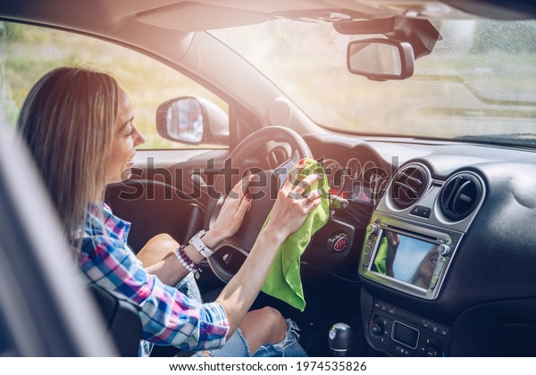 Woman\
uses microfiber cloth with cleaning inside\
car.