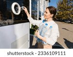 Woman uses a self service machine to receive used plastic bottles and cans on a city street	