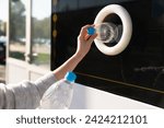 Woman uses a self service machine to receive used plastic bottles and cans on a city street	